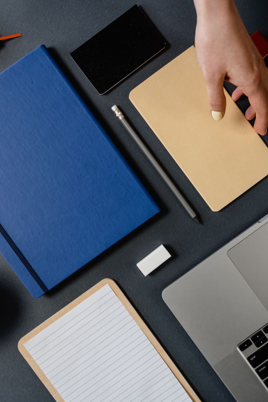 hand picking up notebook from desk